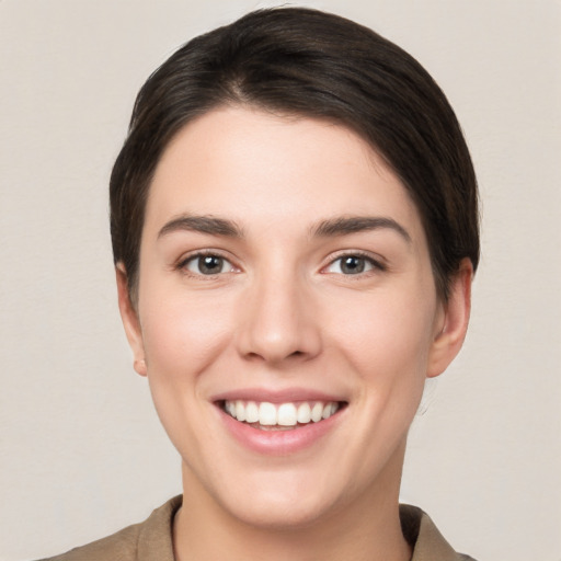 Joyful white young-adult female with short  brown hair and brown eyes