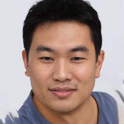 Joyful asian young-adult male with short  black hair and brown eyes