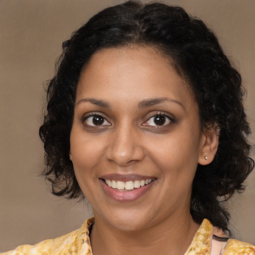 Joyful black young-adult female with medium  brown hair and brown eyes