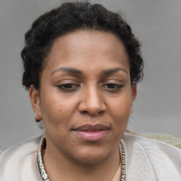 Joyful black adult female with short  brown hair and brown eyes