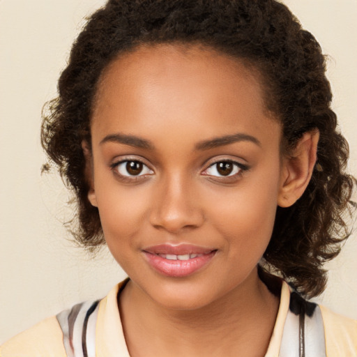 Joyful black young-adult female with long  brown hair and brown eyes