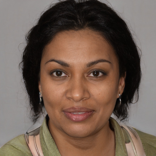Joyful black adult female with medium  brown hair and brown eyes