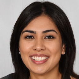 Joyful latino young-adult female with long  brown hair and brown eyes