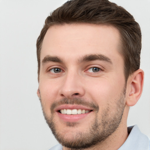 Joyful white young-adult male with short  brown hair and grey eyes