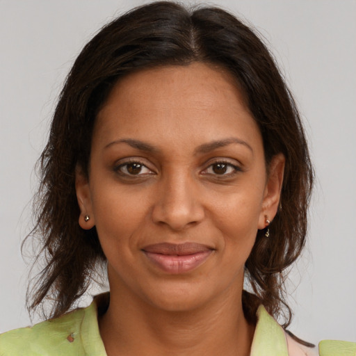 Joyful black young-adult female with medium  brown hair and brown eyes