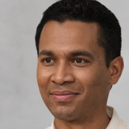 Joyful latino young-adult male with short  black hair and brown eyes