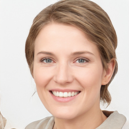 Joyful white young-adult female with medium  brown hair and blue eyes