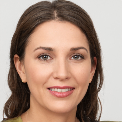 Joyful white young-adult female with medium  brown hair and grey eyes