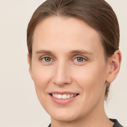 Joyful white young-adult female with medium  brown hair and grey eyes