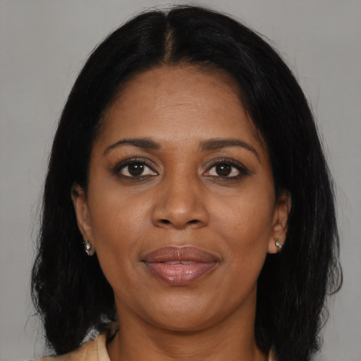 Joyful black young-adult female with long  brown hair and brown eyes