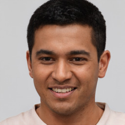 Joyful latino young-adult male with short  brown hair and brown eyes