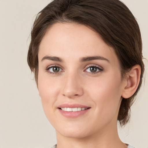 Joyful white young-adult female with medium  brown hair and green eyes