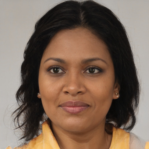 Joyful black adult female with medium  brown hair and brown eyes