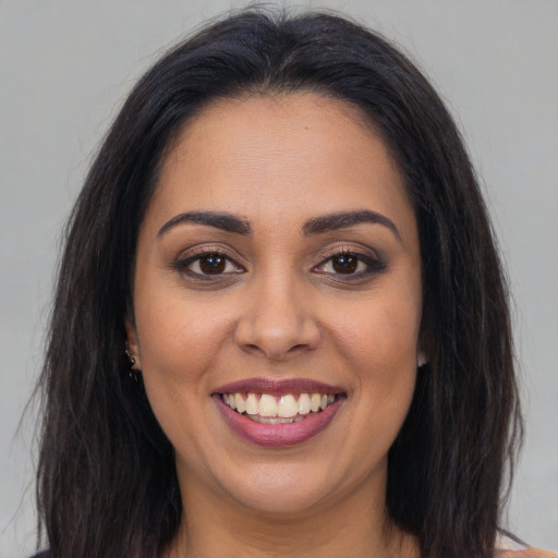 Joyful latino young-adult female with long  brown hair and brown eyes