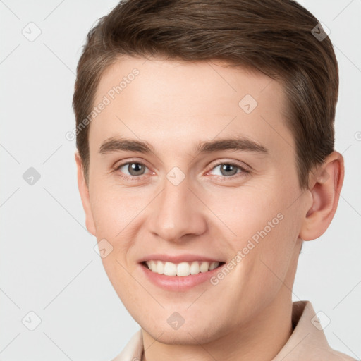 Joyful white young-adult male with short  brown hair and grey eyes