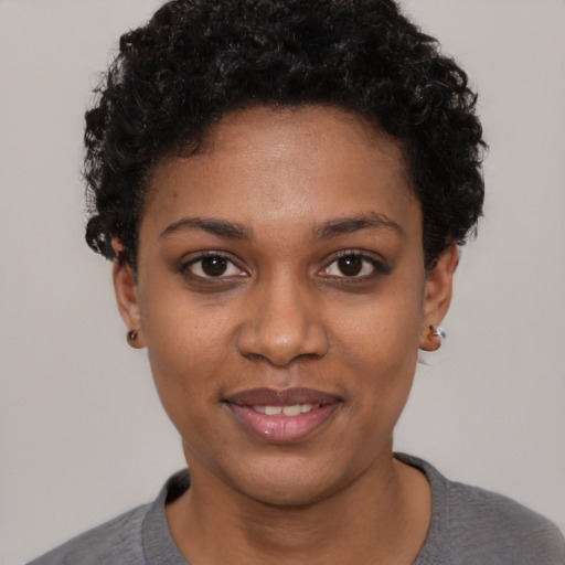 Joyful black young-adult female with short  black hair and brown eyes