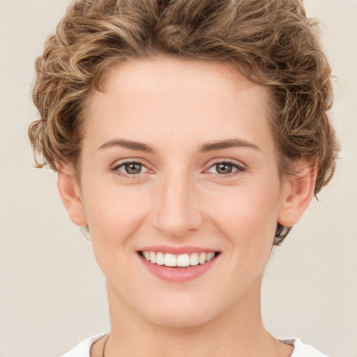 Joyful white young-adult female with short  brown hair and green eyes