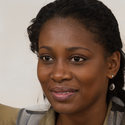 Joyful black young-adult female with long  brown hair and brown eyes