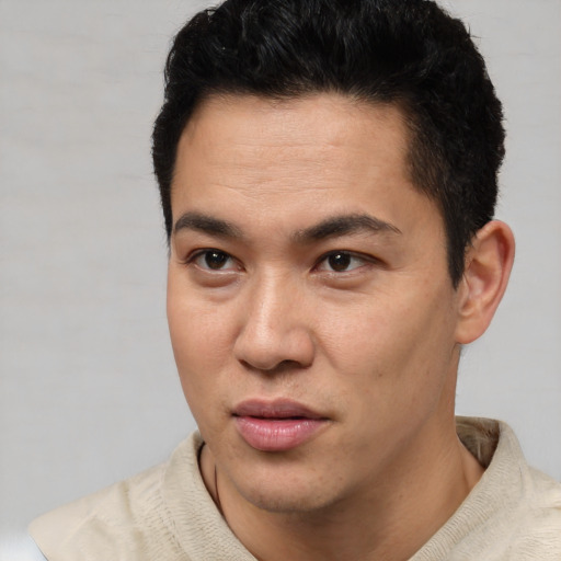 Joyful latino young-adult male with short  black hair and brown eyes