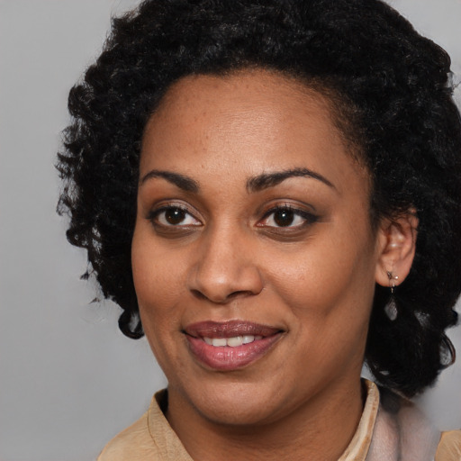 Joyful black adult female with medium  black hair and brown eyes
