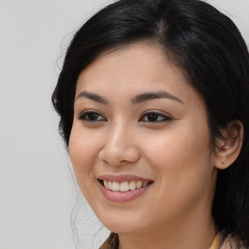 Joyful latino young-adult female with long  brown hair and brown eyes