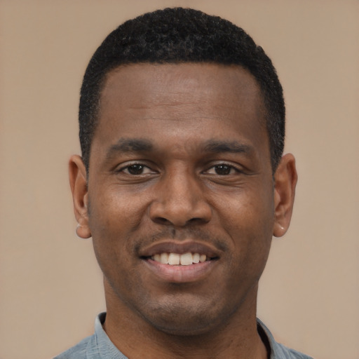Joyful black young-adult male with short  black hair and brown eyes