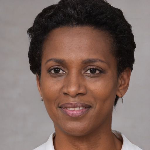 Joyful black adult female with short  black hair and brown eyes