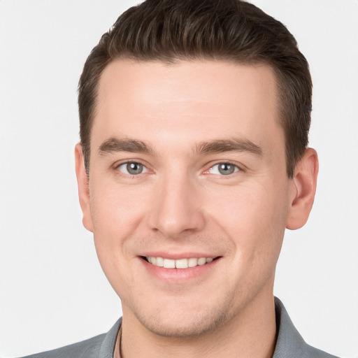 Joyful white young-adult male with short  brown hair and grey eyes