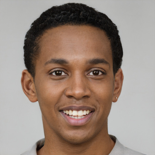 Joyful black young-adult male with short  black hair and brown eyes
