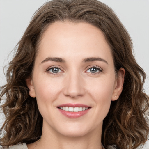 Joyful white young-adult female with long  brown hair and grey eyes