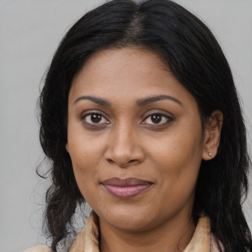 Joyful black young-adult female with long  brown hair and brown eyes
