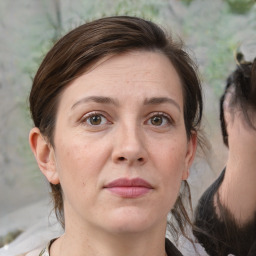 Joyful white adult female with medium  brown hair and grey eyes