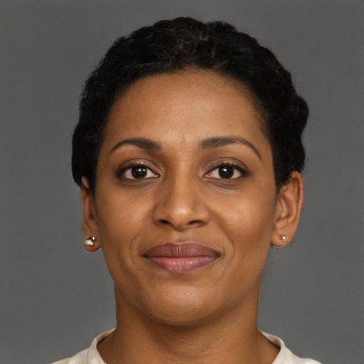 Joyful black young-adult female with short  black hair and brown eyes