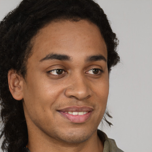 Joyful latino young-adult male with short  brown hair and brown eyes