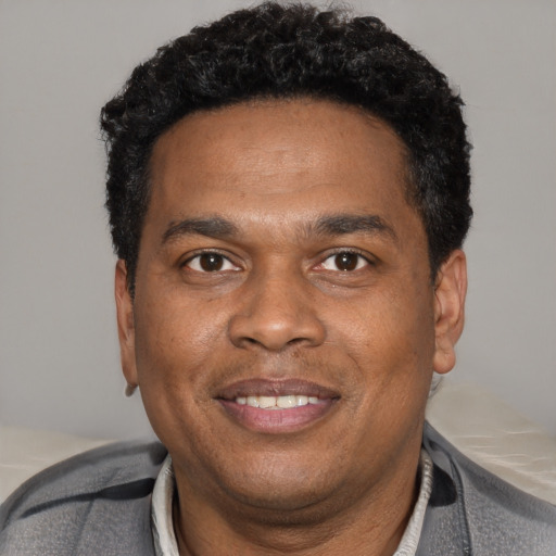 Joyful black young-adult male with short  black hair and brown eyes