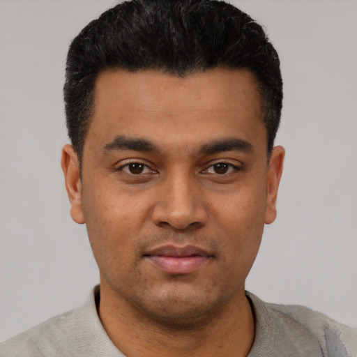 Joyful latino young-adult male with short  black hair and brown eyes