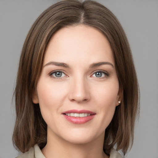 Joyful white young-adult female with medium  brown hair and grey eyes