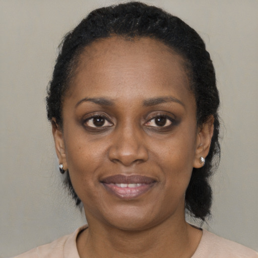 Joyful black adult female with short  black hair and brown eyes