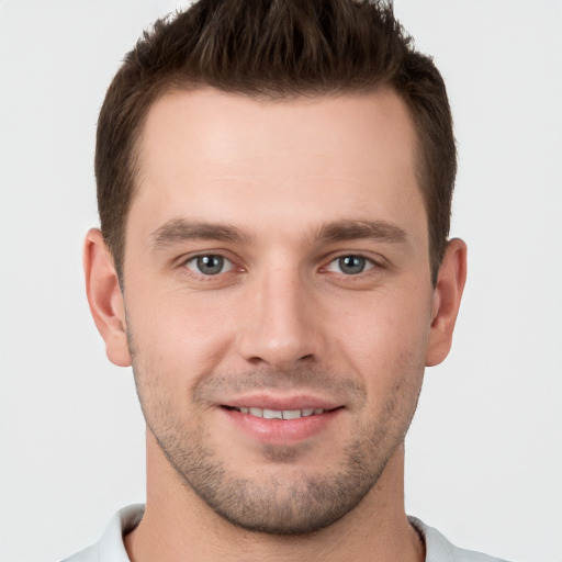 Joyful white young-adult male with short  brown hair and grey eyes