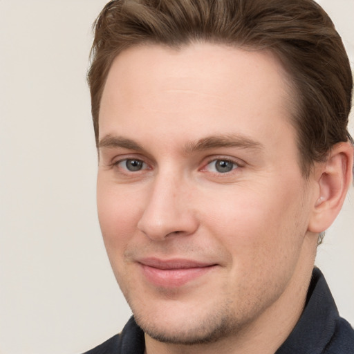 Joyful white young-adult male with short  brown hair and grey eyes