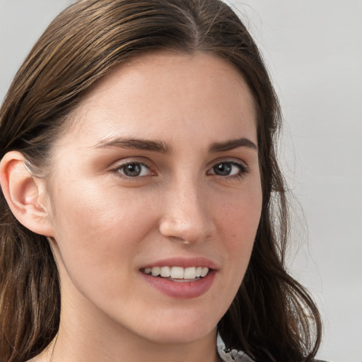 Joyful white young-adult female with long  brown hair and blue eyes