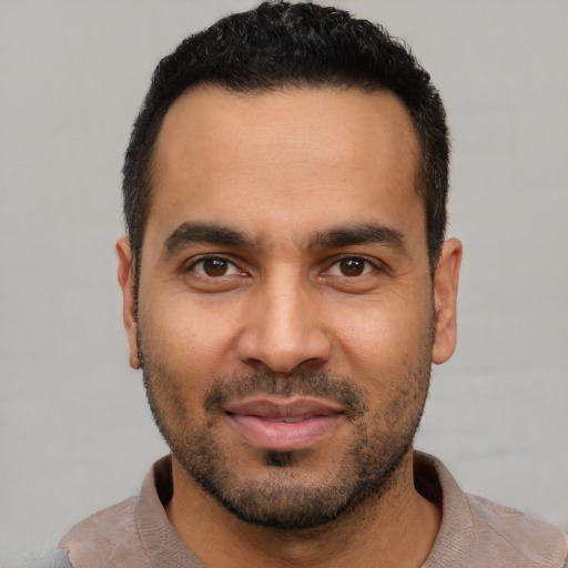 Joyful latino young-adult male with short  black hair and brown eyes