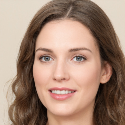 Joyful white young-adult female with long  brown hair and green eyes