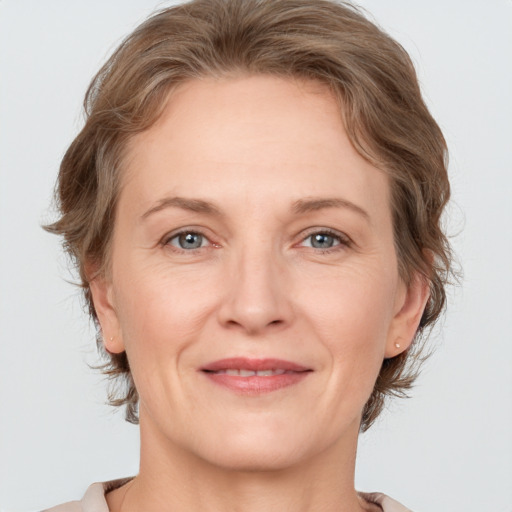 Joyful white adult female with medium  brown hair and grey eyes