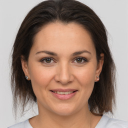 Joyful white young-adult female with medium  brown hair and brown eyes