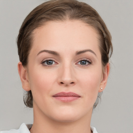 Joyful white young-adult female with medium  brown hair and grey eyes