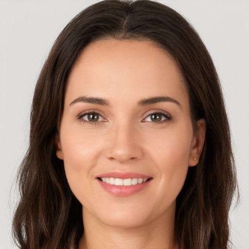 Joyful white young-adult female with long  brown hair and brown eyes