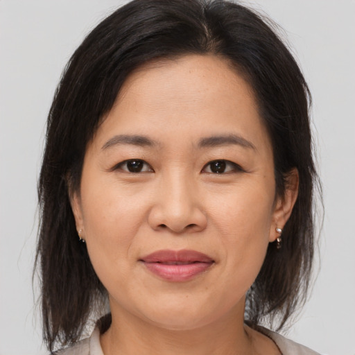 Joyful asian adult female with medium  brown hair and brown eyes