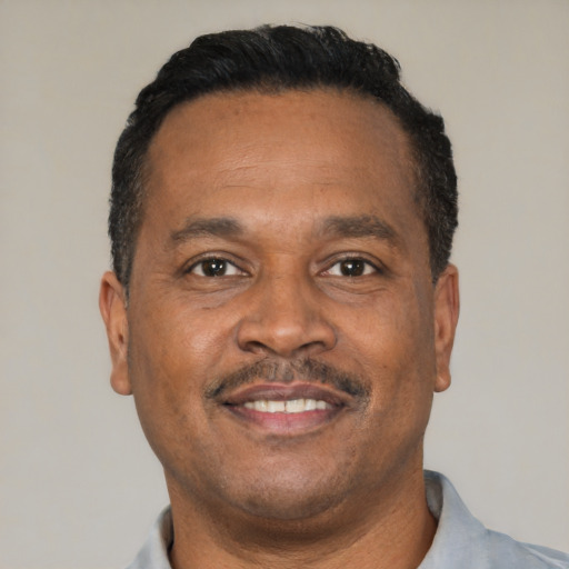 Joyful latino adult male with short  black hair and brown eyes