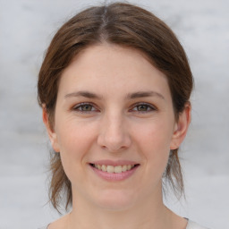 Joyful white young-adult female with medium  brown hair and grey eyes